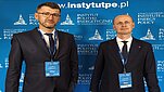 Dr hab. inż. Tomasz Włodek i dr inż. Krzysztof Polański przed ścianką konferencyjną Politechniki Rzeszowskiej