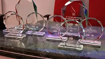 Nagrody Przewidziane dla zwycięzców Konferencji East meet West- szklane przezroczyste trofea stojące na zielonym marmurowym blacie
