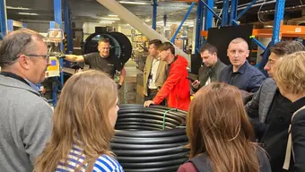 Zdjęcie przedstawiające przedstawicieli WNiG oraz Studentów przy linii produkcyjnej firmy Muvitech