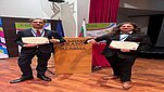 Studenci WWNiG oparci o mównicę na Konferencji SGEM w Albenie/Bulgaria. Widoczne postacie studentów (widok do pasa) trzymających dyplomy za uczestnictwo w tym wydarzeniu.
